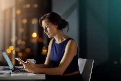 Woman sitting in at table at night looking pensive