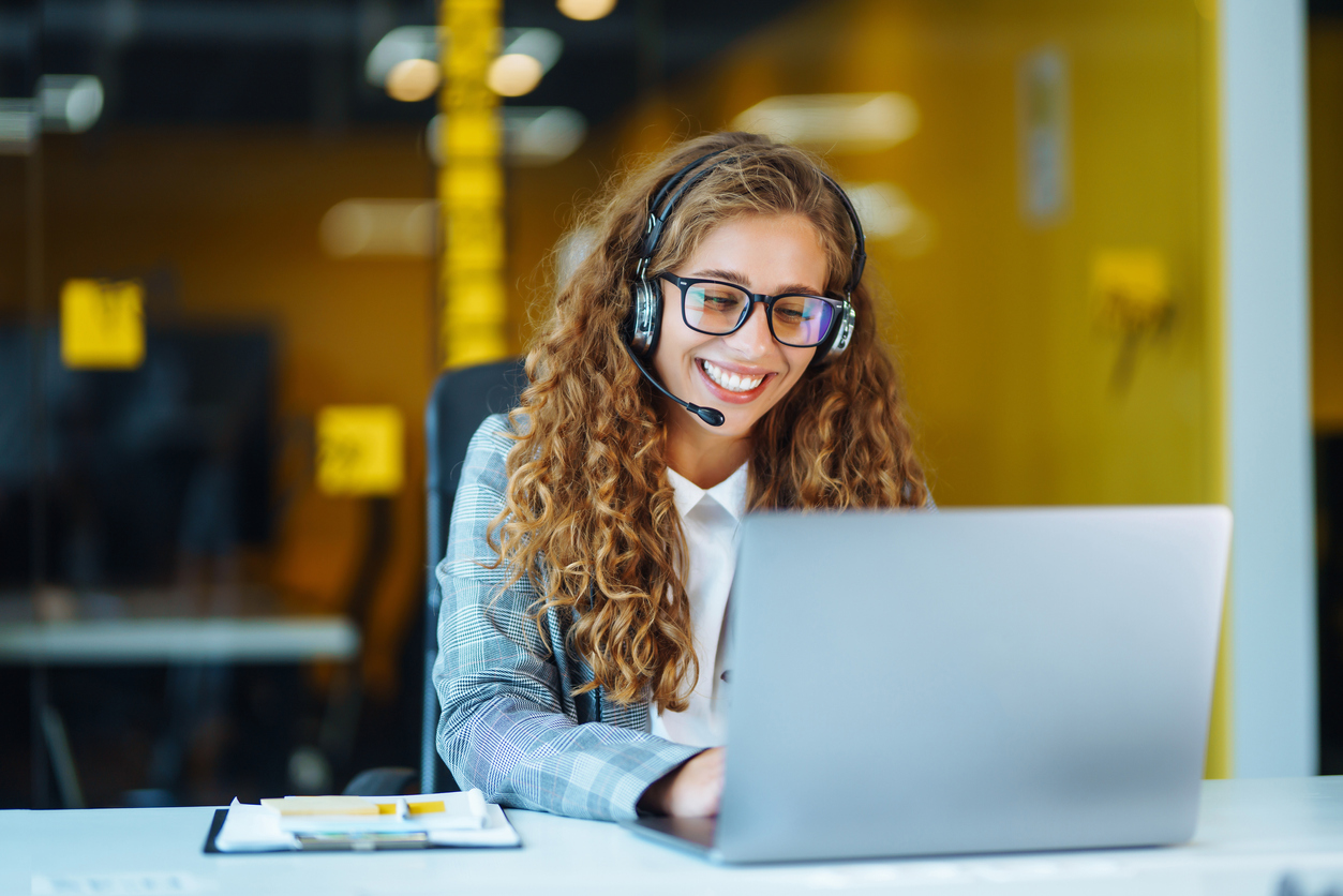 Call center agent with headset working in an office