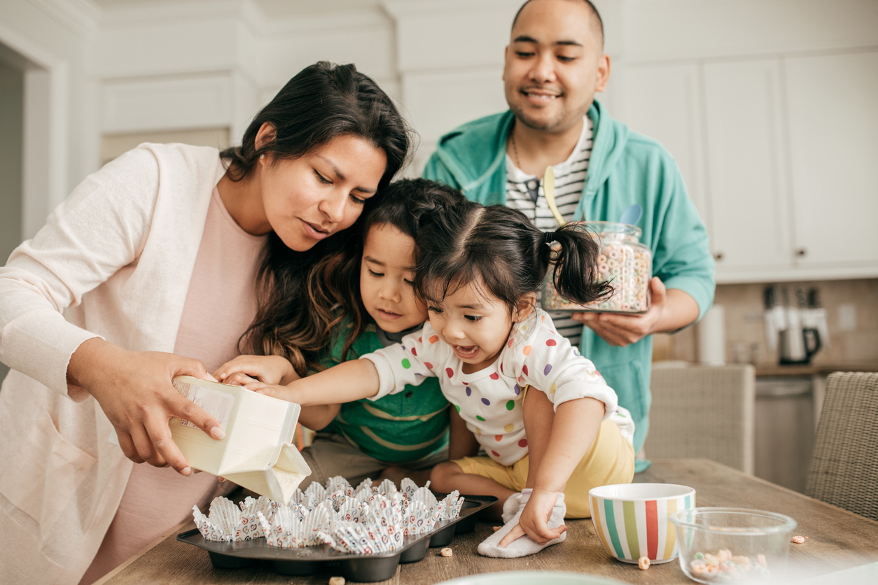 Two parents and two children baking together in a kitchen iStock-690675694 (1)